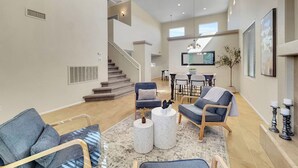 Un grand espace de vie comprenant un escalier, un coin repas et une cuisine.