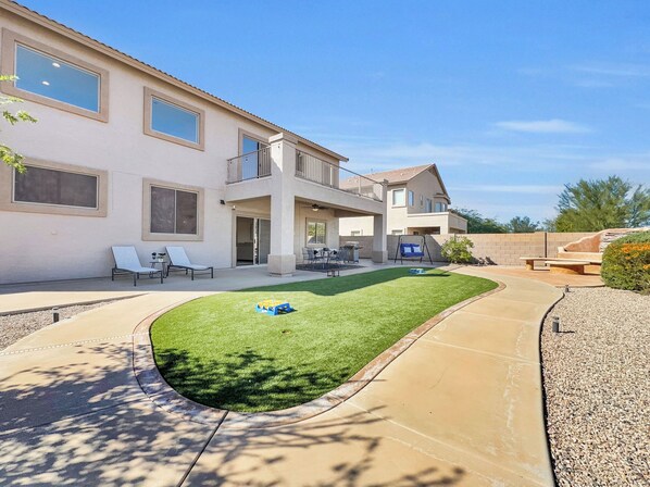Une maison à deux étages avec un patio, une pelouse et une piscine.