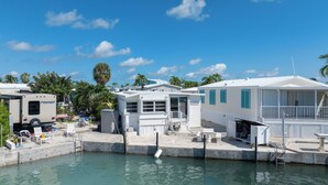 A marina with several white mobile homes, a swimming pool, and a trailer. - Florida Keys Canal-Front 2BR/2BA w/ 35' Seawall, Dock & Spacious Comfort (Cudjoe Key)