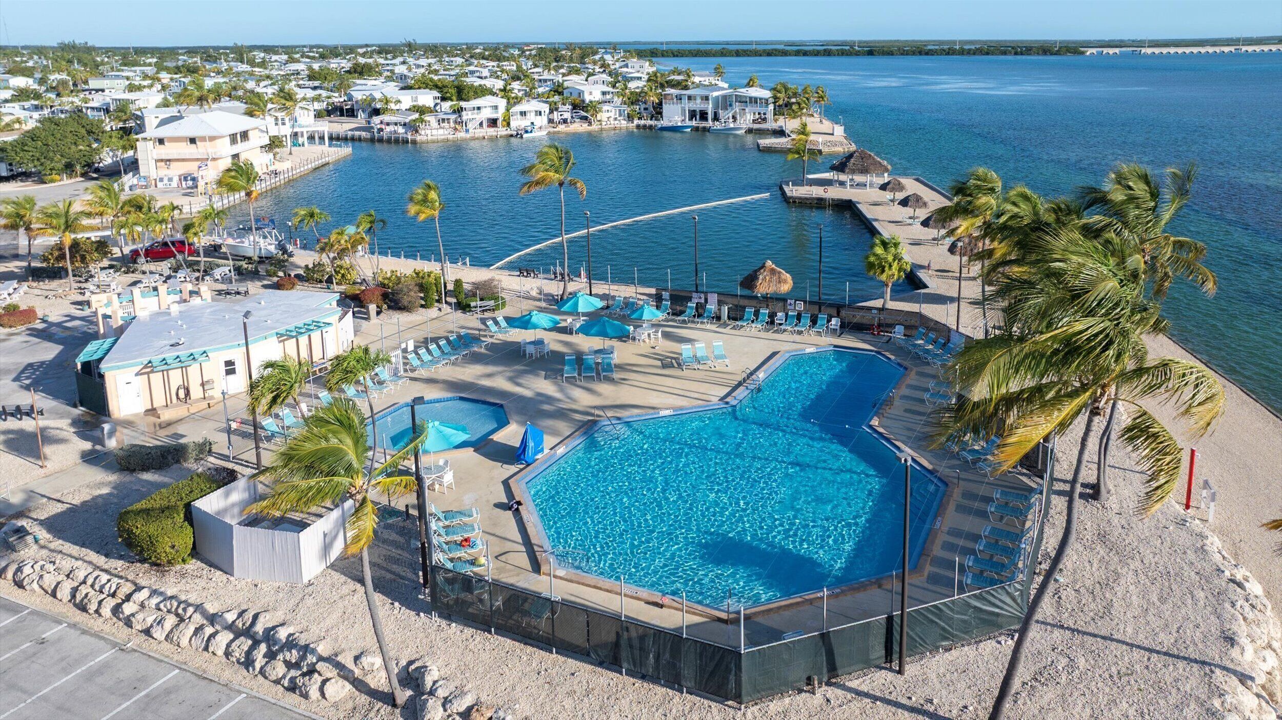 A resort with multiple swimming pools, a beach area, and a view of the ocean.