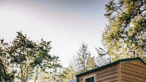 Une cabane en bois avec une véranda, une porte et des fenêtres.