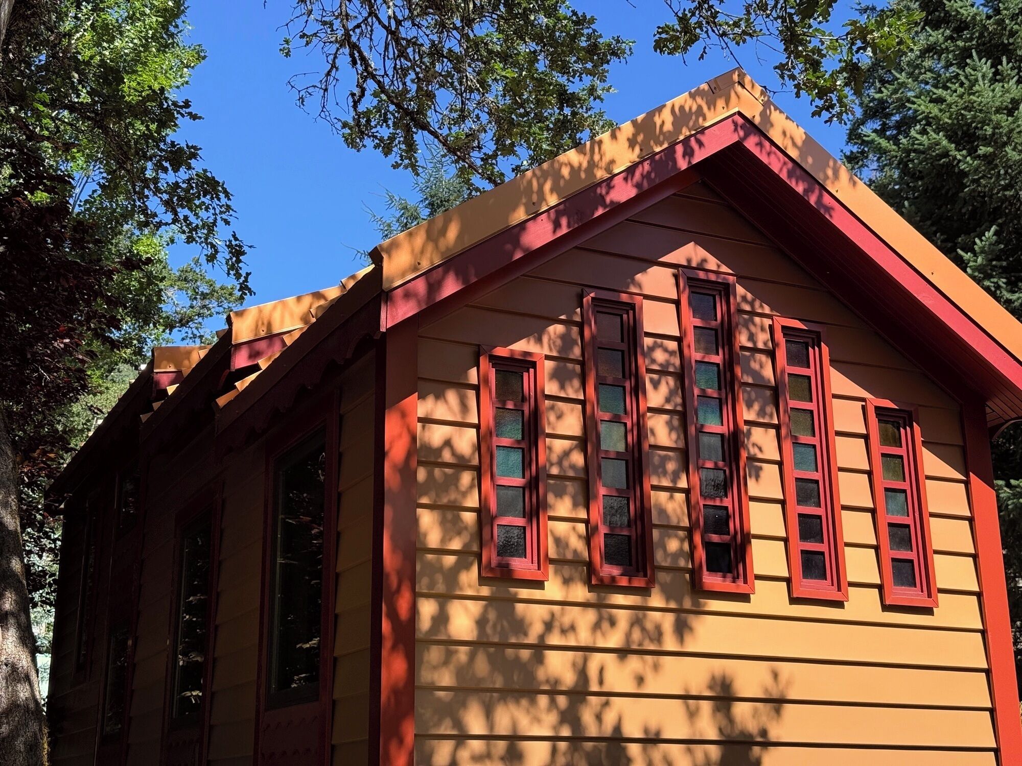 Un edificio amarillo con detalles en rojo y numerosas ventanas.