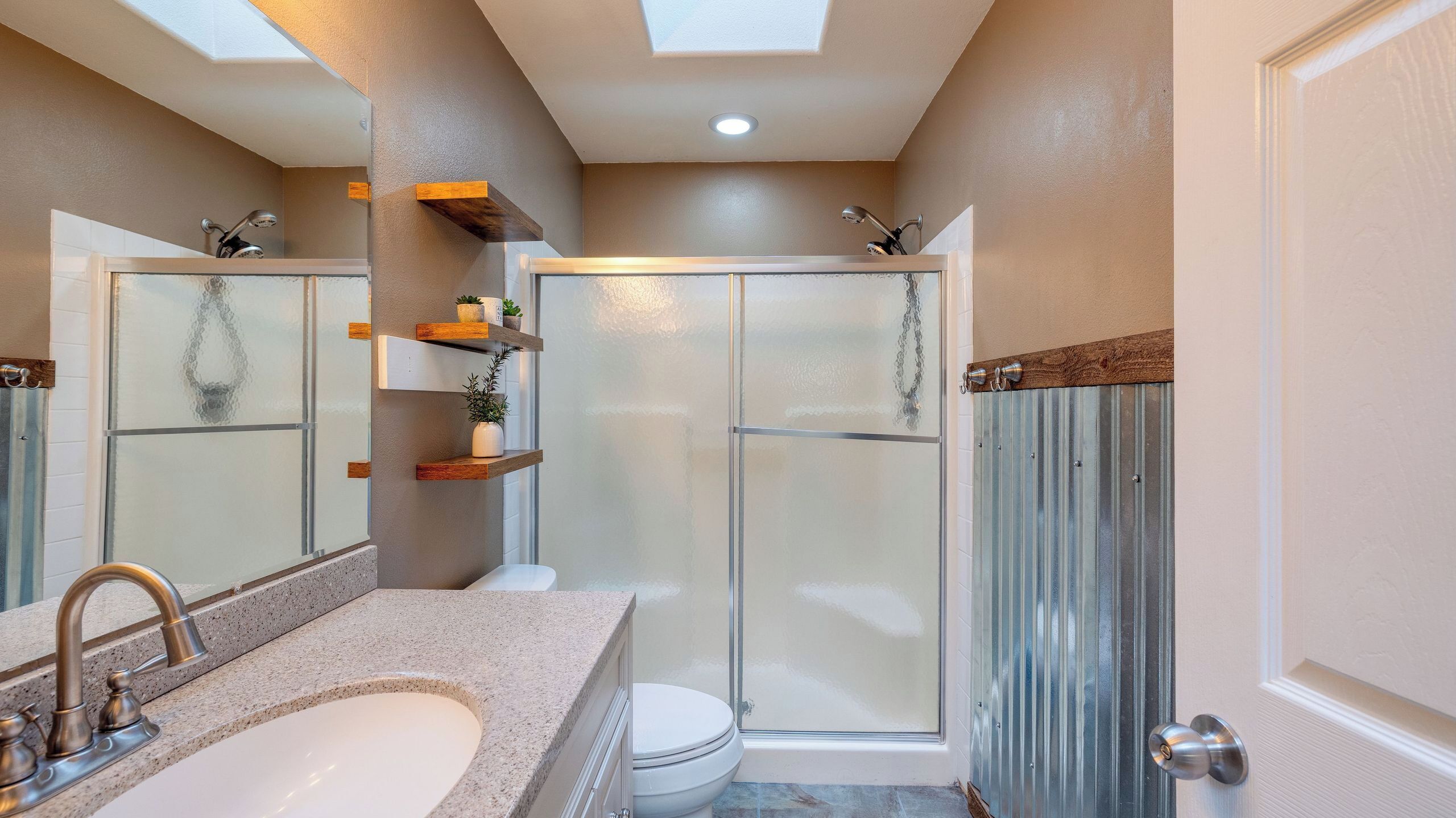 A bathroom with a shower, toilet, and sink.