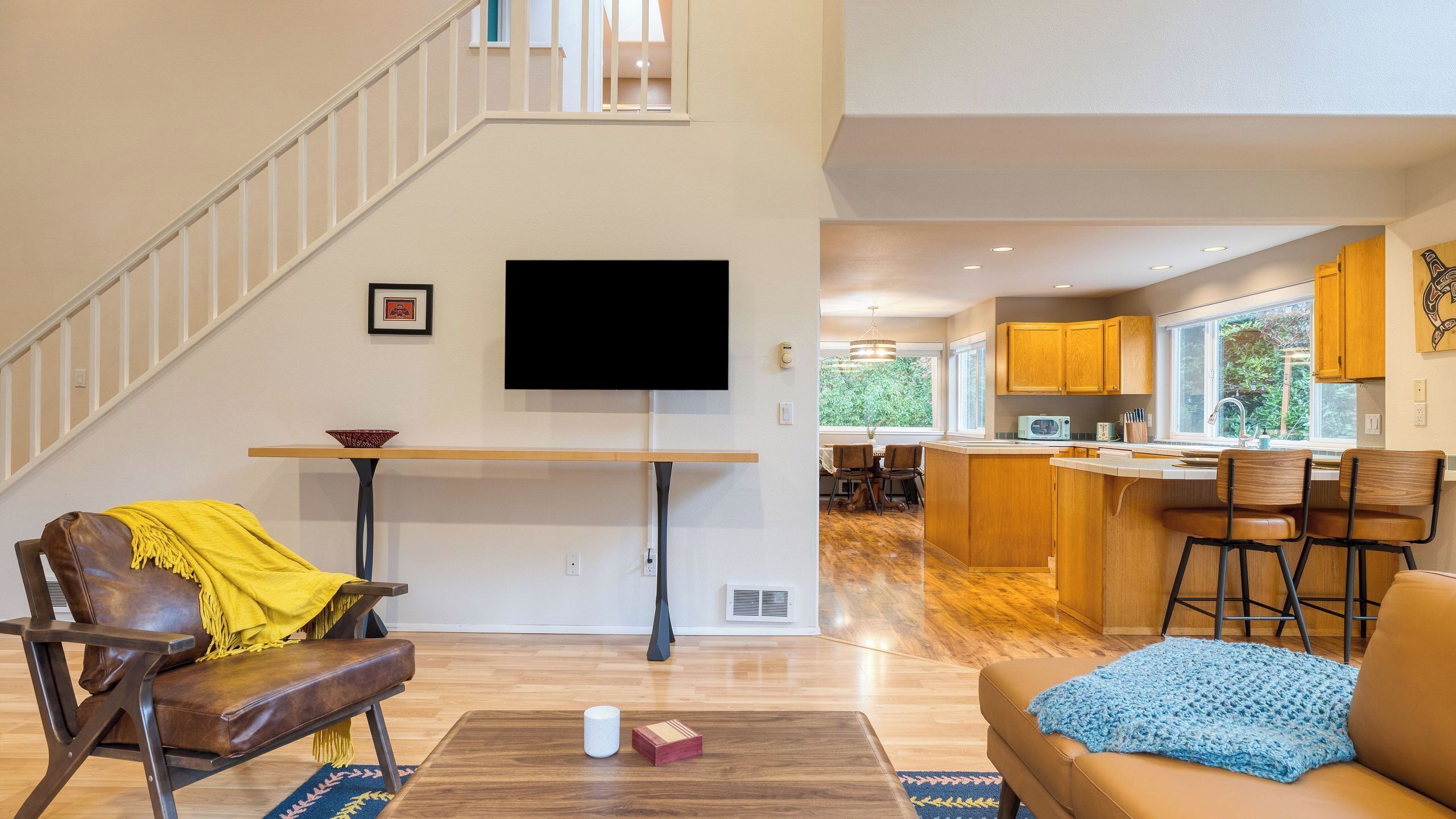 A modern living room with a sofa, a coffee table, and a TV mounted on the wall.
