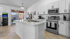 Una cocina moderna con armarios blancos, electrodomésticos de acero inoxidable y una isla central.