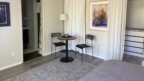 A modern hotel room with a bed, a small round table with chairs, a lamp, and a painting on the wall. - Private Sedona retreat with private hot tub (Sedona)