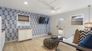 A spacious living area with a kitchen, a dining table, and a sofa.