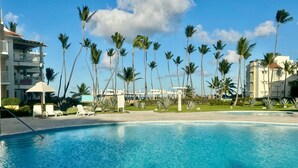 Una piscina con palmeras y edificios al fondo.