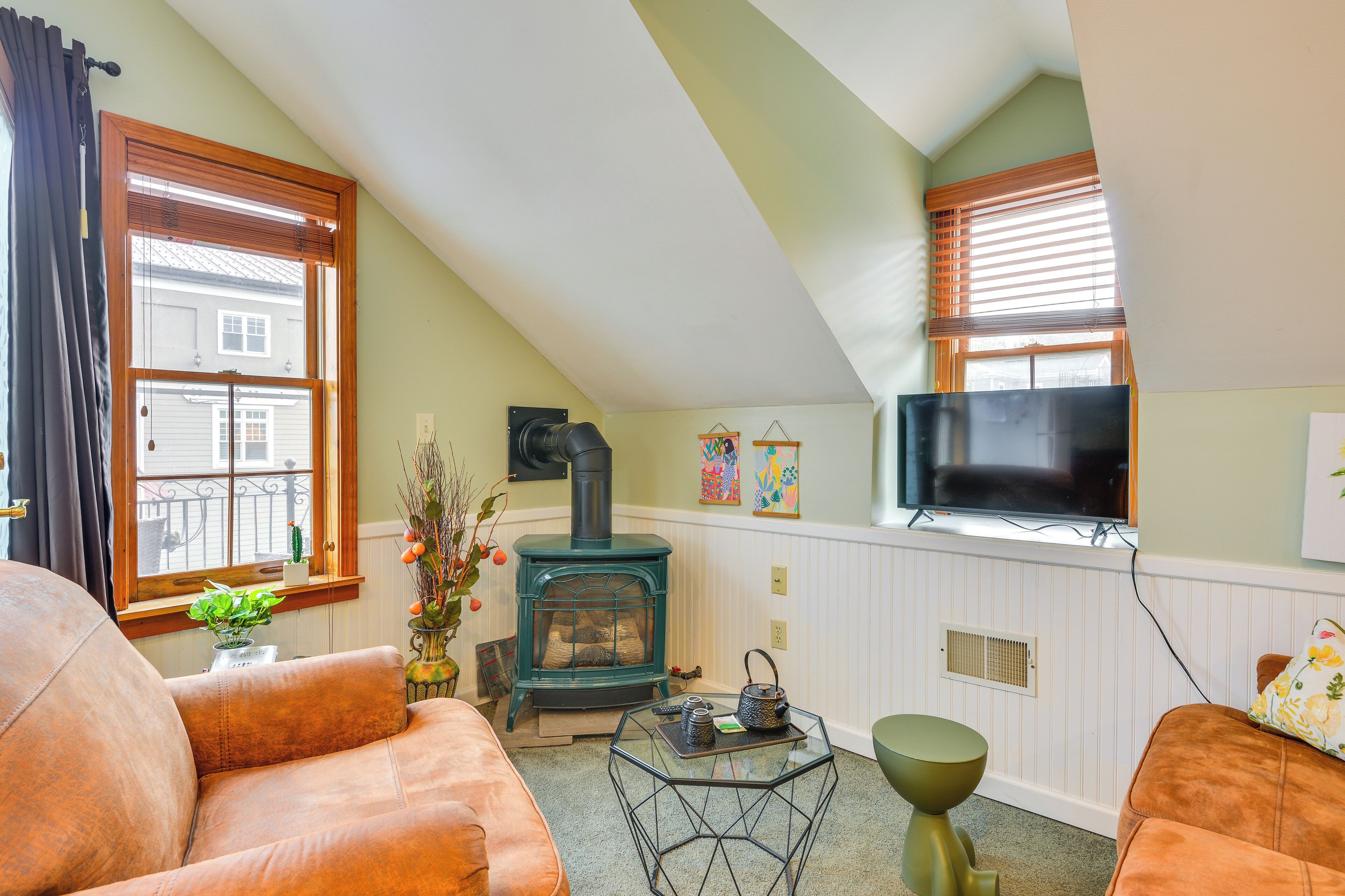 A cozy living room with a fireplace, comfortable seating, and a flat-screen TV.