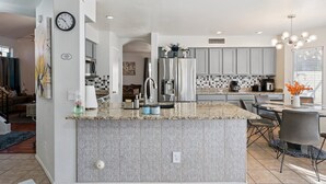 A modern kitchen with granite countertops, stainless steel appliances, and a central island.