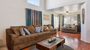 A spacious living room with two sofas, a coffee table, and a large window.