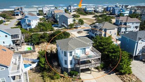 A residential area with houses, a beach access path, and a view of the ocean. - Sea Time - Corolla, Ocean Sands, Oceanside Retreat, 280 Yds to Beach, Close to Golf and Shopping (Corolla)