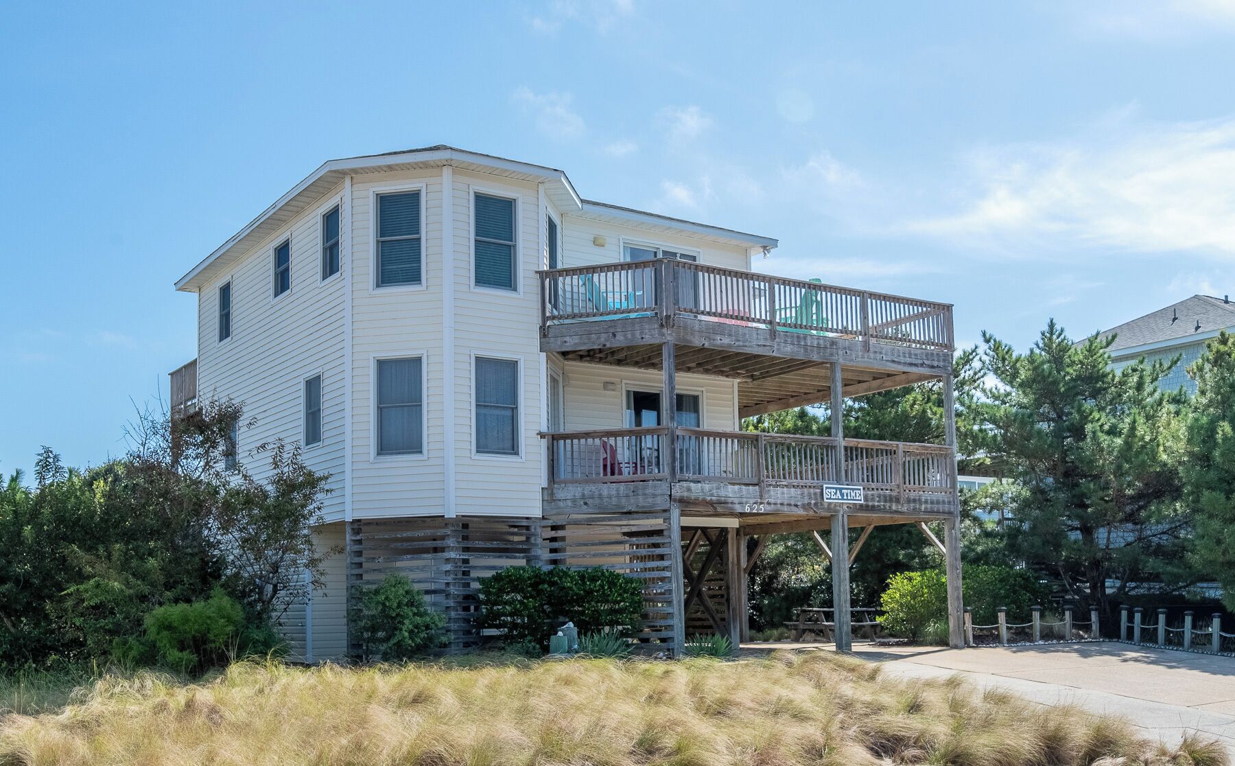 A two-story building with a balcony on the upper floor, a sign reading "SEA TIME," and a number "625" on the balcony railing.