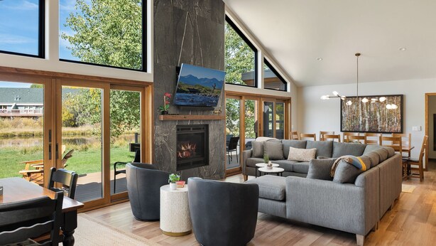Un salón amplio con chimenea, ventanas grandes y comedor.