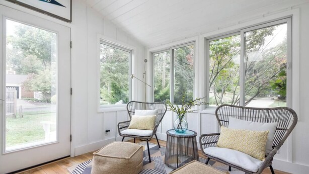 A sunlit room with large windows, wicker furniture, and a patterned rug. - Pet-Friendly Oasis w/ Sunroom – Steps to Beach! (Douglas)