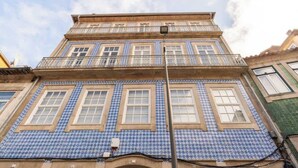 A building with a blue and white patterned facade, multiple windows, and a balcony. - Central & Cozy Studio by HostWise (Vila Nova de Gaia)