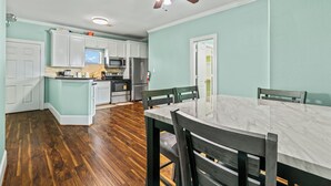 A kitchen with white cabinets, a microwave, and a refrigerator. - Sunny Hidden Retreat C – Ocean Town Gem (Galveston)