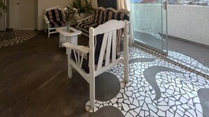 Una sala de estar moderna con un conjunto de sofá, una mesa de comedor y un ventanal con vistas a un paisaje urbano.