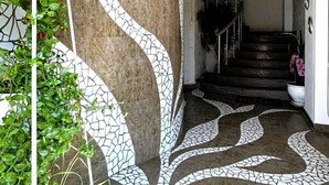 Una escalera con un diseño de mosaico único, que lleva a una zona de descanso con una planta en maceta.