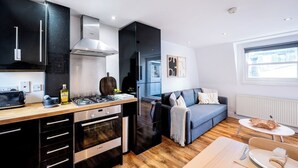 A modern kitchen with a Bosch gas stove, black cabinets, and a wooden countertop.