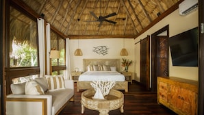 A bedroom with a bed, a nightstand, a TV, and a wooden cabinet.