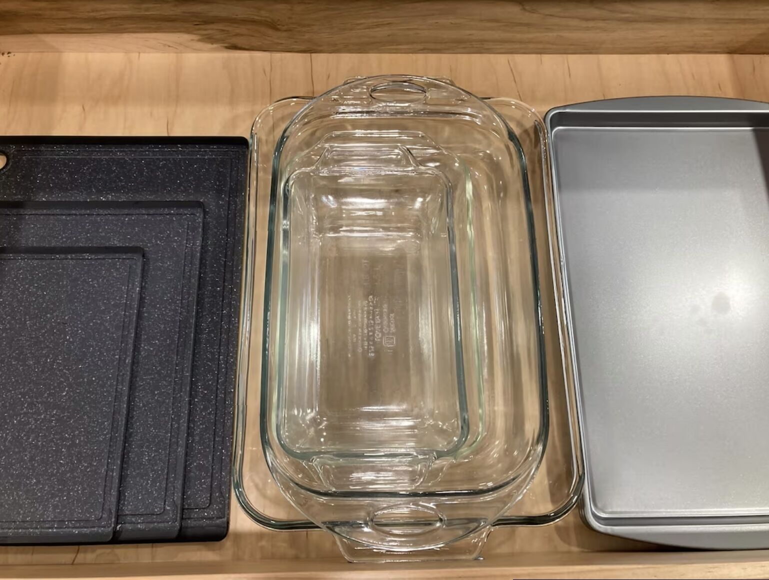 A clear glass baking dish with measurement markings, placed on a wooden surface.