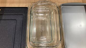 A clear glass baking dish with measurement markings, placed on a wooden surface.