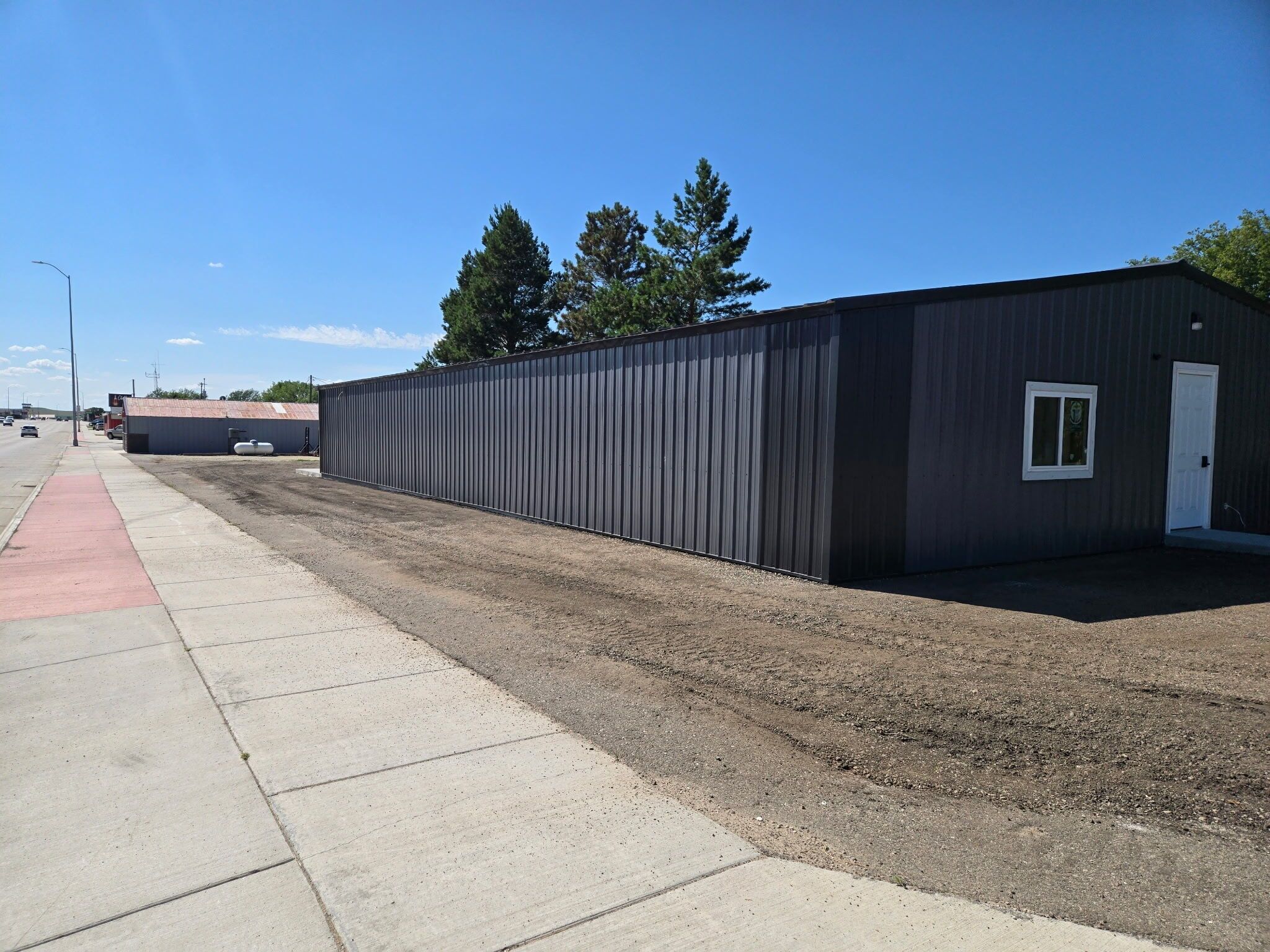 A single-story industrial building with a flat roof, a door, and a small window.