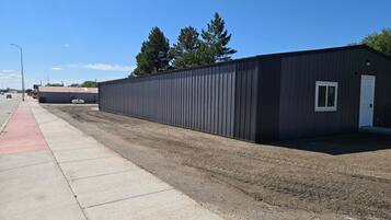 A single-story industrial building with a flat roof, a door, and a small window.