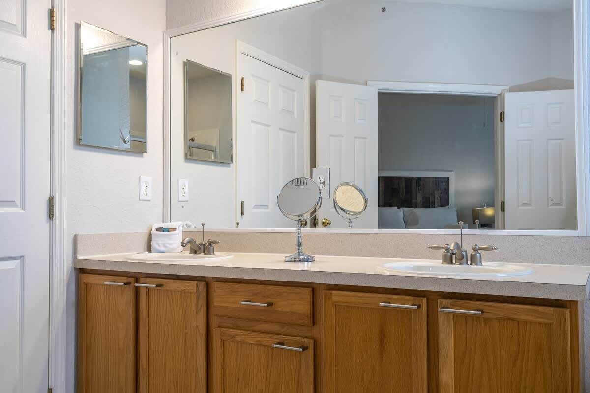 Une salle de bain avec un double lavabo, des meubles en bois et deux miroirs.