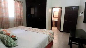 A hotel room with a bed, a desk, and a wardrobe.
