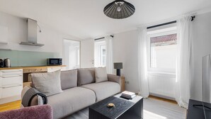 Una sala de estar moderna con un sofá, una mesa de centro, una lámpara y un televisor.