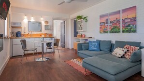 A compact living space with a kitchenette, a dining area, and a seating area with a sofa and a coffee table. - King + 2 Queen Beds | 3 Smart TV`s | *WALK to LU* (Lynchburg)
