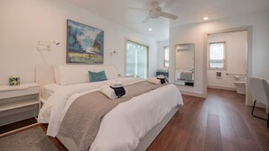 A modern bedroom with a large bed, a ceiling fan, and a painting on the wall. - King + 2 Queen Beds | 3 Smart TV`s | *WALK to LU* (Lynchburg)