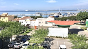 A coastal town with buildings, a marina, and parked cars. - Charming Apartment Near the Beach and Town Centre (Roses)