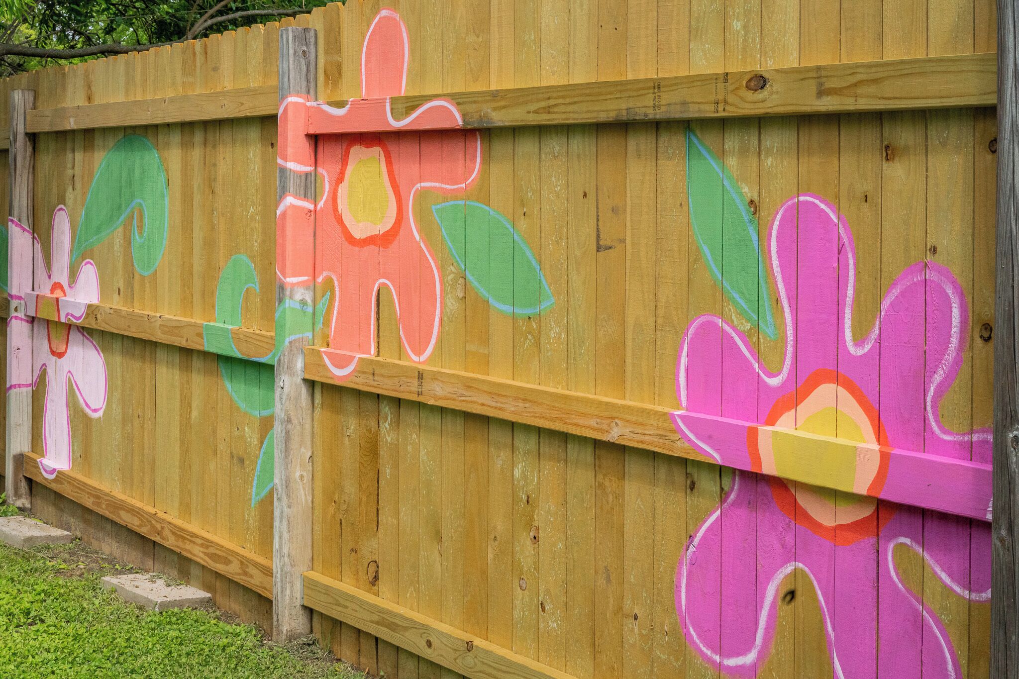 Una cerca de madera con alegres decoraciones florales.