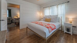 A bedroom with a bed, bedside table, nightstand, ceiling fan, and a door leading to another room. - Walk to Eats & Shops • Decatur Courthouse View (Decatur)