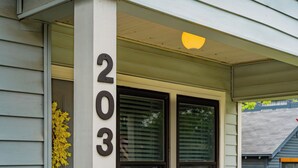 A house number 203 on a white wall, a window with blinds, and a door with a yellow flower arrangement. - Walk to Eats & Shops • Decatur Courthouse View (Decatur)