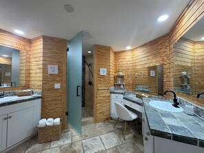A modern bathroom with wooden paneling, a shower, a vanity with a sink, and a mirror.