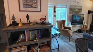 Ein Wohnzimmer mit Bücherregal, Fernseher und Holzboden.