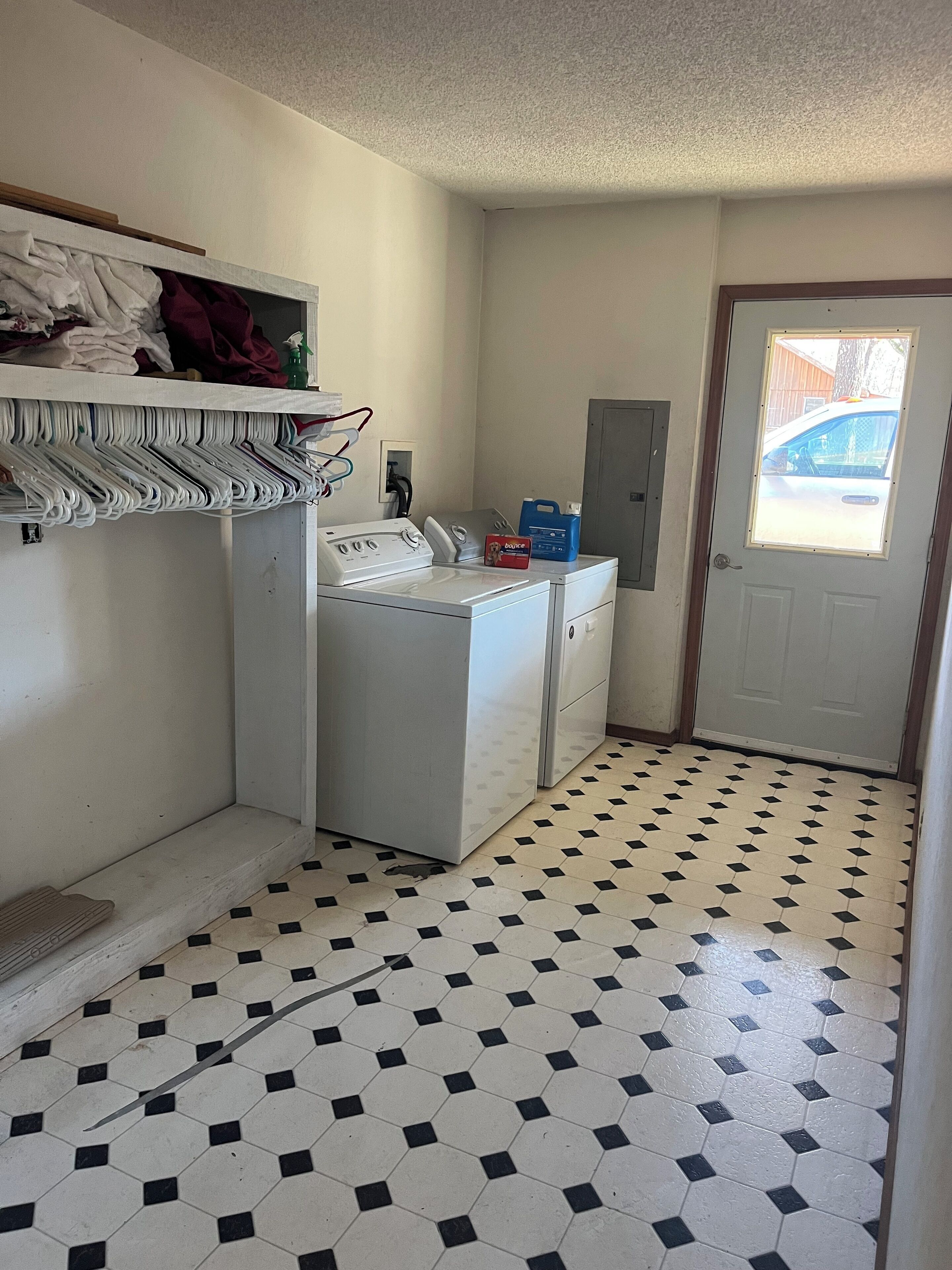 A laundry room with a washing machine, dryer, and stacked laundry.