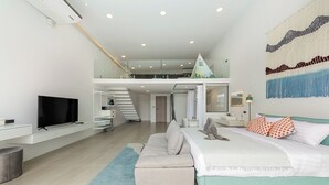 A modern bedroom with a bed, a TV, a staircase, and a bathroom. - Unique Pool Slide Access Townhouse (Bophut)