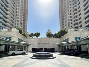 Edificio moderno con patio central, que cuenta con una fuente, rodeado de edificios residenciales altos.
