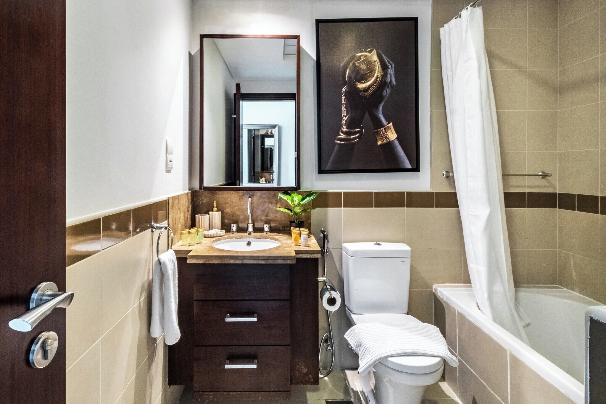 A modern bathroom with a sink, toilet, and bathtub.