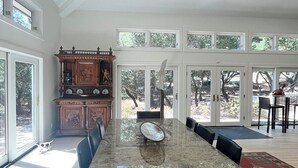 A spacious dining area with a long table, chairs, and a large window offering a view of the outdoors. - Beautiful Riviera Guest Suite in Private Forest, Conveniently Located Retreat (Santa Barbara)