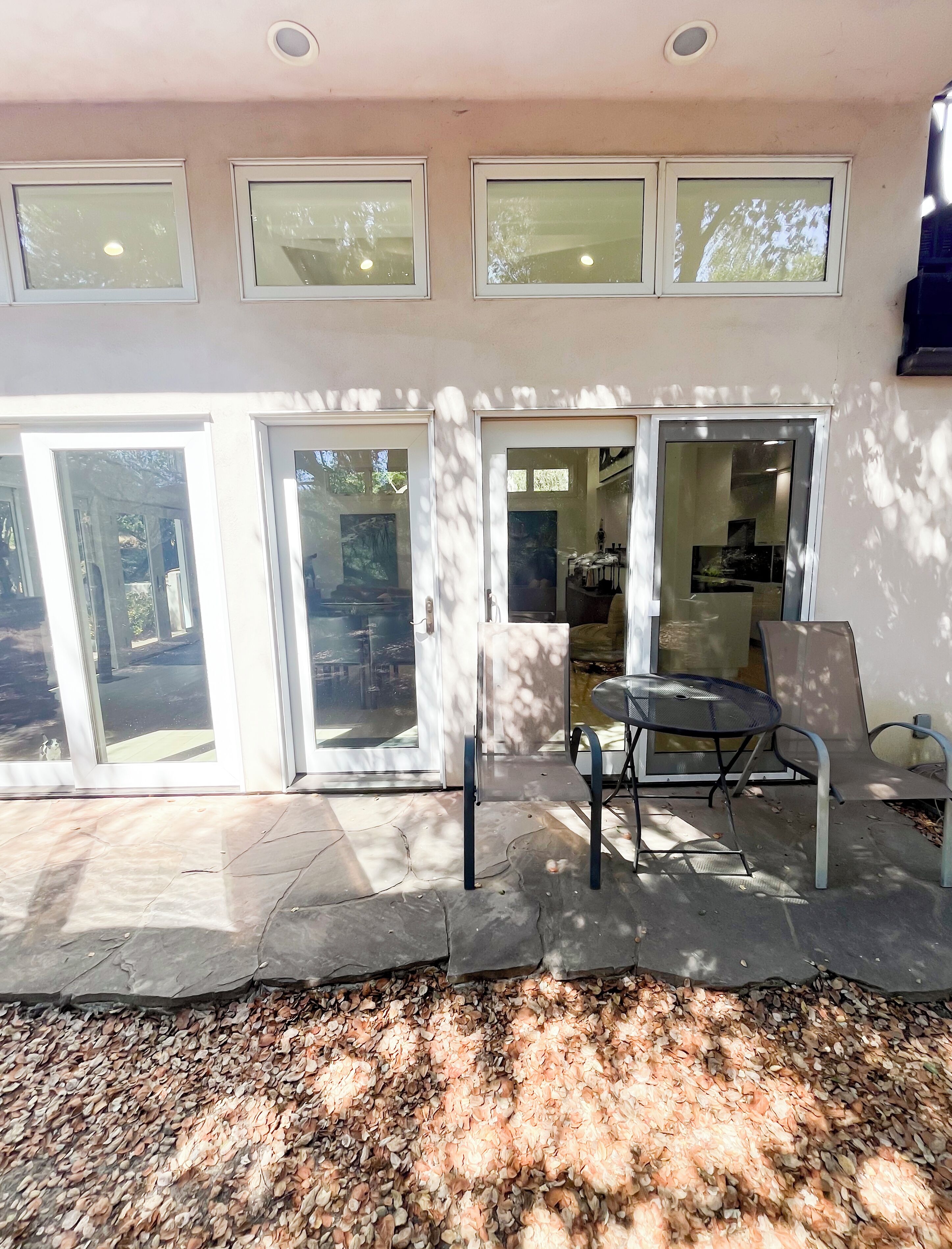 Una casa moderna con amplios ventanales que dan a un patio.
