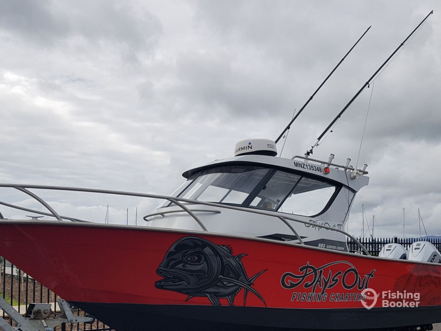 A fishing charter boat with a red and white hull, a fish graphic, and the name 'Angout Fishing Charters'.