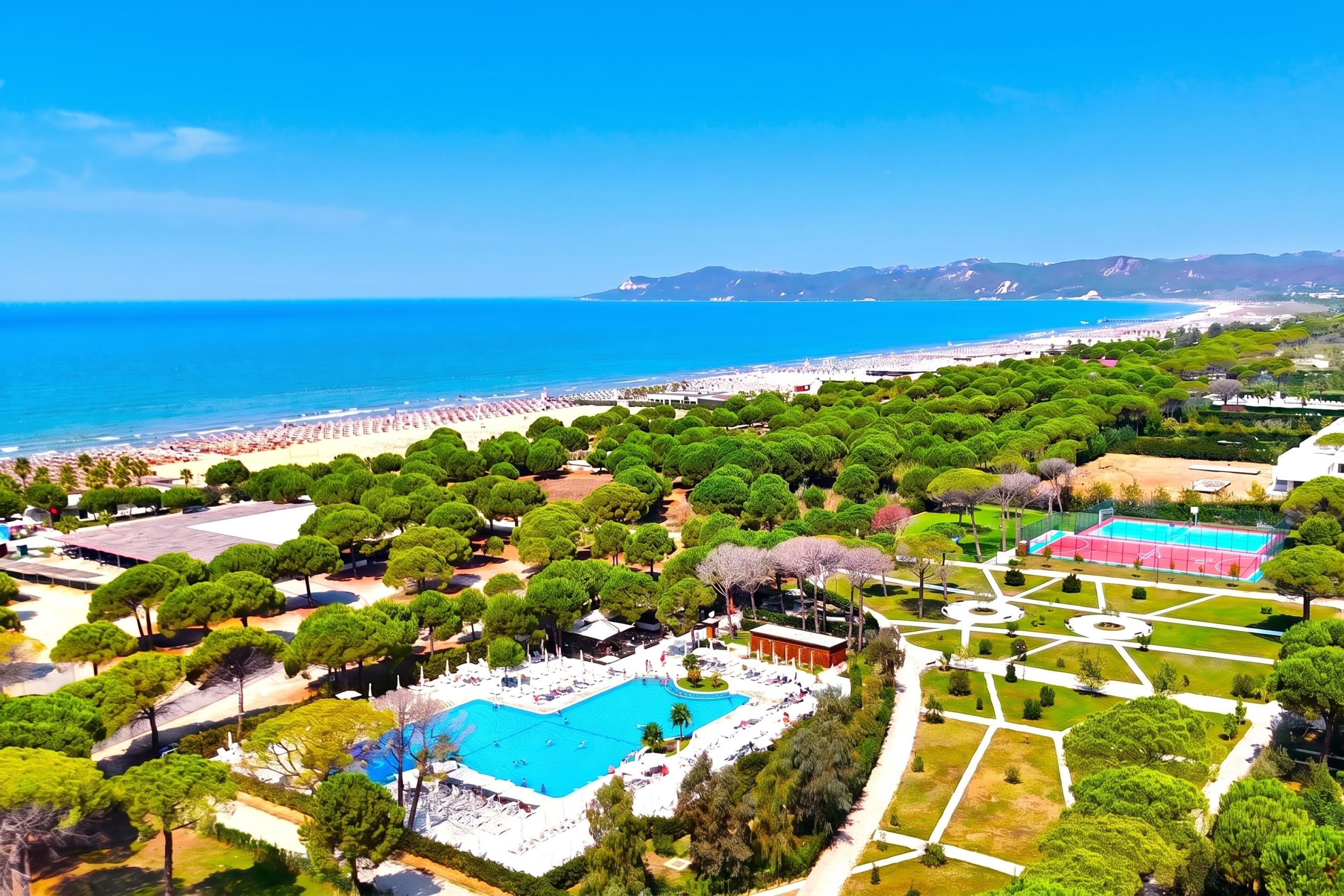 A resort with a swimming pool, beach, and landscaped gardens.