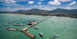 Vista aérea de un puerto deportivo con varios muelles y barcos.