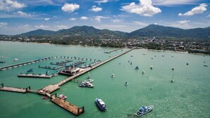 An aerial view of a marina with multiple docks and boats. - Garden View Apt- 1BR T1-103 (Chalong)